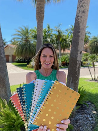 Karen Rae holding 6 planners in hands