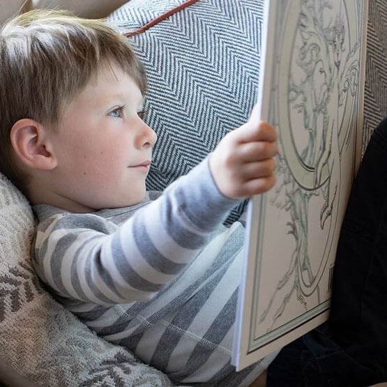 a little boy is reading the Quest for Brightland