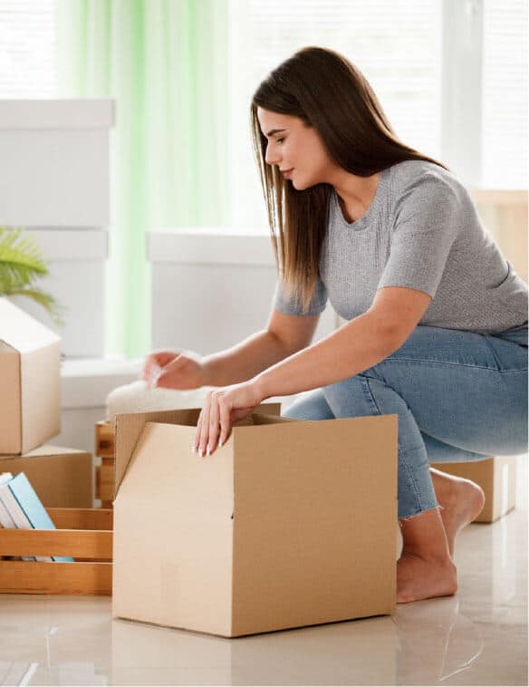A woman is packing books to a box